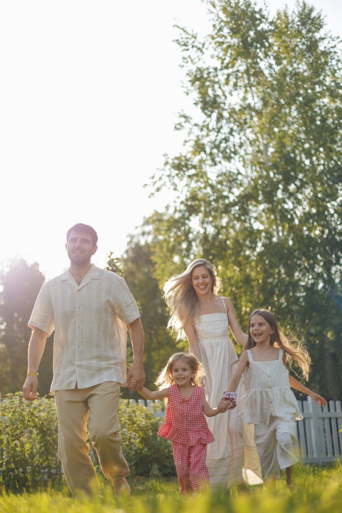 Une famille heureuse court ensemble dans un jardin ensoleillé.